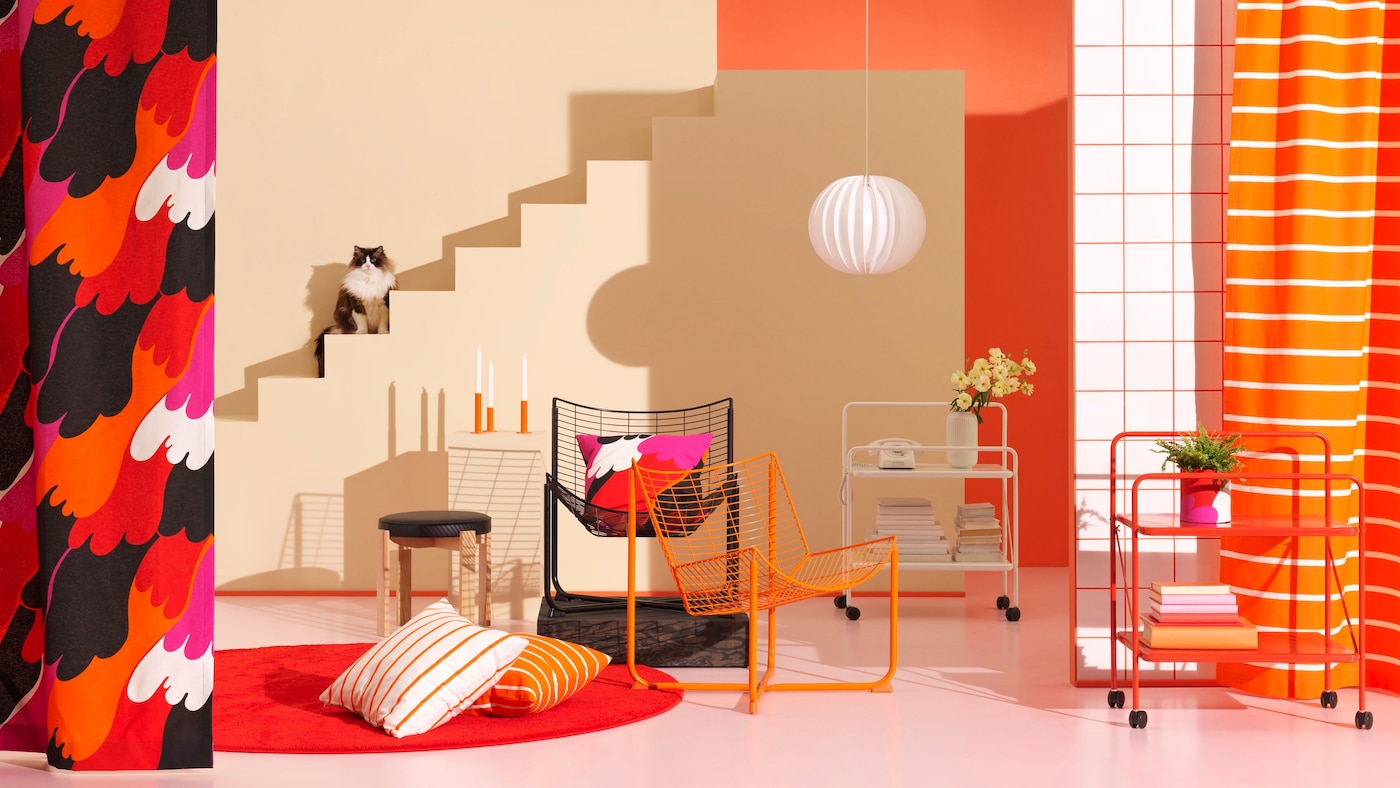 A roomset featuring brightly coloured furniture. In the background, a cat sits on a staircase.